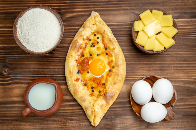 面包俯视图美味的鸡蛋面包刚从烤箱里拿出来放在棕色桌子上的面团面包包早餐午餐烘焙烤箱