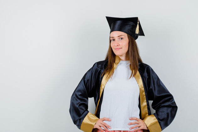 Cap女毕业生穿着学院服 双手放在腰上 看起来很自豪正面图学位保持大学