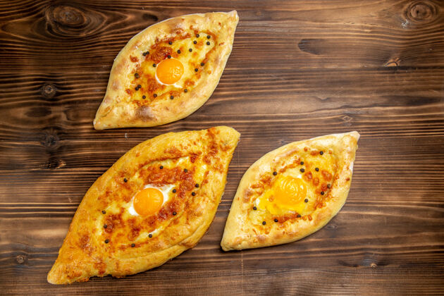 比萨饼顶视图烤鸡蛋面包从棕色桌子上烤箱新鲜的面团鸡蛋面包包早餐烘焙生的膳食
