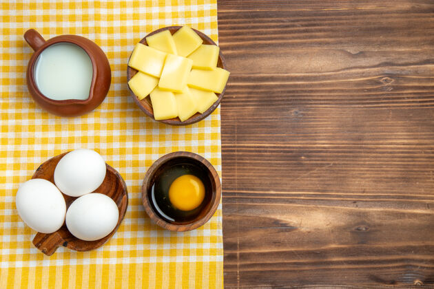按钮顶视图生鸡蛋与奶酪和牛奶放在一个木制的表面产品生鸡蛋面团餐食品膳食颜色顶部