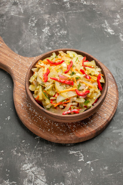 特写侧特写镜头沙拉蔬菜沙拉在棕色碗上的木制厨房板食物板沙拉