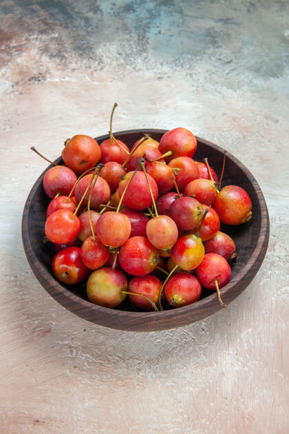 餐桌樱桃红黄色的樱桃放在桌上的木碗里苹果碗樱桃