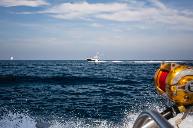 蓝天在蓝天下的海浪上航行的渔船的镜头帆船海洋海
