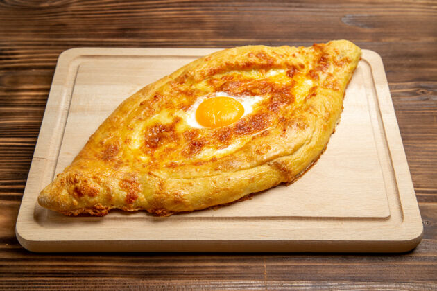 生的顶视图新鲜的烤面包和煮熟的鸡蛋放在棕色的木制桌子上面团餐包早餐鸡蛋食品桌子晚餐视野
