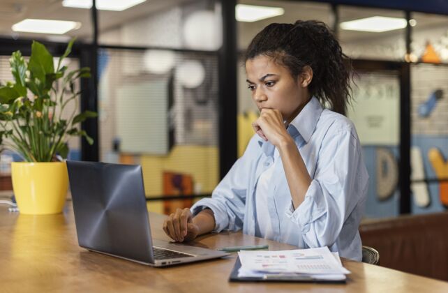 水平在办公室工作的女士手持笔记本电脑的侧视图职业工作空间女人