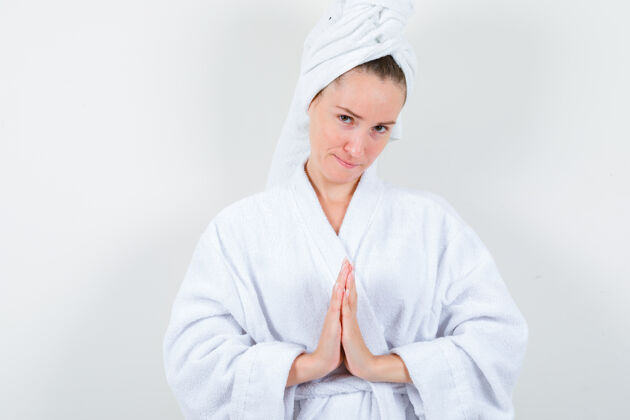 完美身穿白色浴袍的年轻女士 手拿毛巾做祈祷的姿势 看上去充满希望 正前方的景色女性成人举行