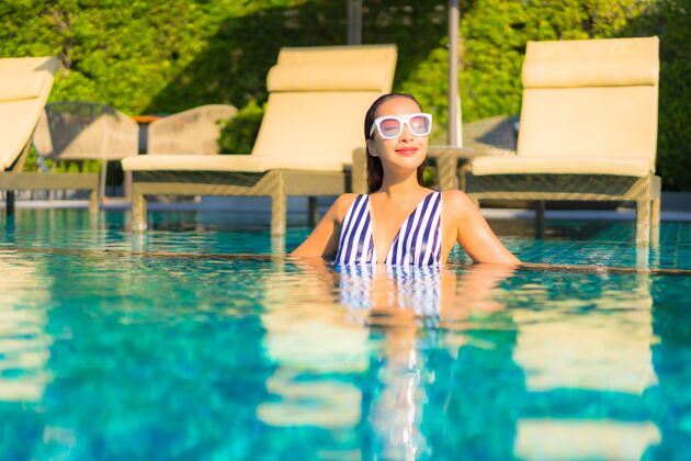 泳装肖像美丽的年轻女子放松微笑休闲度假酒店游泳池周围亚洲人成人阳光