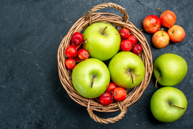 史密斯奶奶顶视花篮上有水果青苹果和甜樱桃 表面呈深灰色 水果组成醇厚的新鲜树顶部樱桃可食用水果