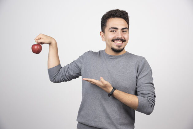 模型黑发男人指着灰色的红苹果肖像男孩食物