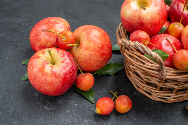 壁板侧面特写查看水果樱桃和红黄色的苹果在篮子里美味特写食物