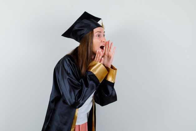 女性女毕业生身着学院服大声喊叫或宣布某事的画像 看起来很兴奋的正面视图Cap学术前