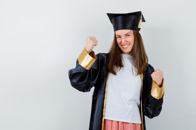 长袍毕业的女人穿着休闲服 穿着制服 看起来很幸福 正前方是赢家的姿态学校人民教育