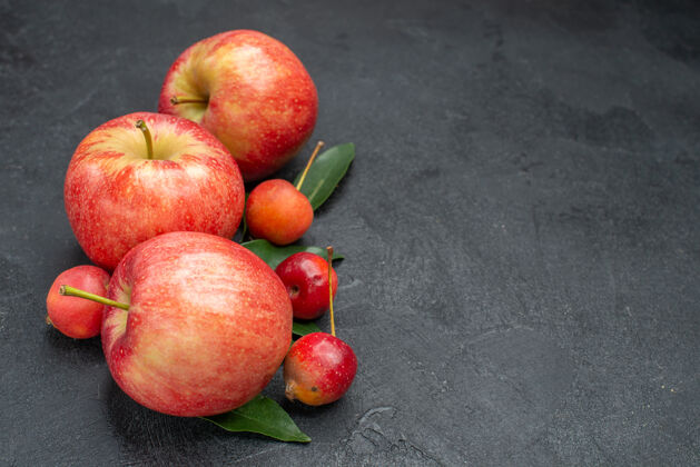 美味侧面特写查看水果开胃浆果和苹果与树叶叶子壁板吃苹果