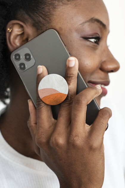 背面手机后面的圆形电话夹与非洲裔美国妇女在讲电话背面电话移动