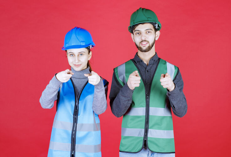 展示男女工程师戴着头盔和装备注意前方的人人装备制服
