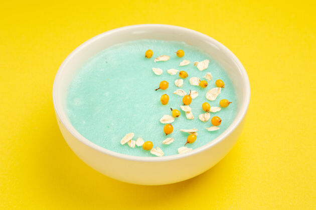 汤前视图蓝色冰甜点在盘子里放在黄色桌上牛奶麦片的颜色新鲜里面前面