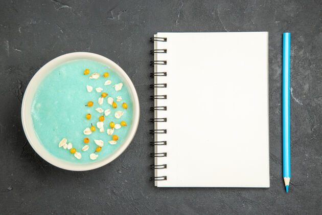 书写顶视图蓝色冰甜点内板上深色地板奶油冰色笔记本办公室空白