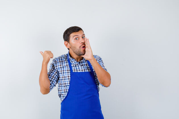 制服穿着蓝色围裙和衬衫的年轻男厨师帅哥成人男士