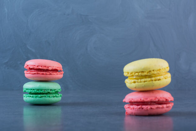 糖深灰色表面上有不同颜色的通心粉饼干糖果美食糖果