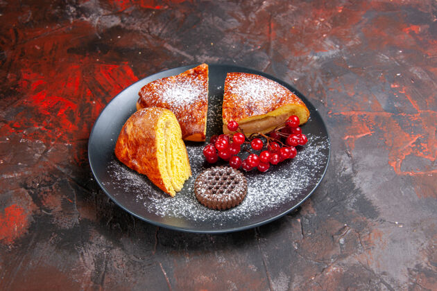 多汁前视图美味的切片派与红色浆果在黑暗的桌子上蛋糕饮食农产品