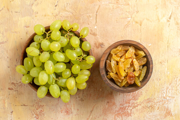 素食顶部特写镜头：葡萄桌上放着一碗碗的绿色葡萄和葡萄干餐桌串顶部