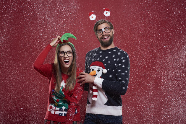 圣诞节一对疯狂的夫妇穿着有趣的圣诞开衫女人手势怪人