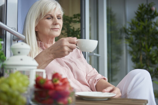 早餐在阳台上享受美味咖啡的熟女特写镜头咖啡女人老年妇女