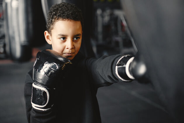 训练年轻勤奋的拳击手学习拳击孩子在体育中心孩子开始了一个新的爱好肖像运动装力量