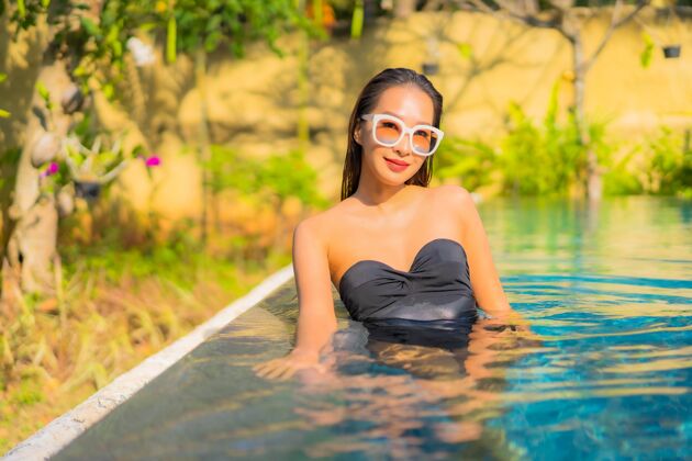 人美丽的亚洲年轻女子在游泳池里放松的画像美丽游泳池假日