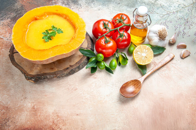 美食侧面特写查看汤匙西红柿大蒜柑橘类水果油南瓜板上的汤健康胡椒蔬菜