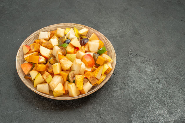 果仁前视图美味水果沙拉由新鲜水果组成 灰色地板上有许多新鲜水果食物正面谷物