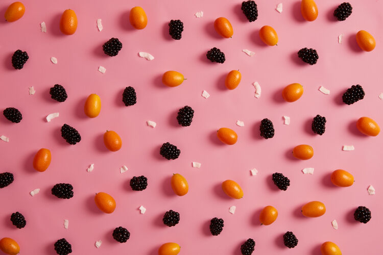 细节粉红色背景上有各种新鲜成熟的水果甜黑莓 橘子金橘和白巧克力片平面图和俯视图多汁有机食品 维生素c 夏季营养黑莓新鲜多汁