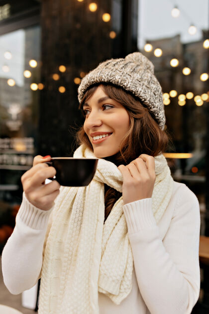 大学造型的形象 欧洲妇女在针织帽和围巾喝咖啡 享受冬天在外面的时间学习咨询魅力