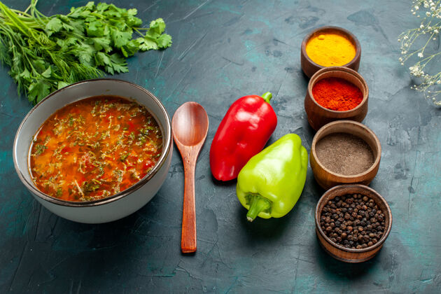 汤俯瞰美味的蔬菜汤 用不同的调味料放在深绿色的菜面上 食用一餐蔬菜配料汤产品生产胡椒膳食