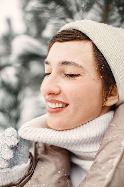 雪雪地公园里一个穿着棕色夹克的女人的特写肖像公园冬天霜冻