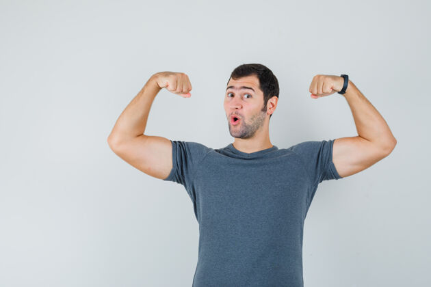 技术网络穿着灰色t恤展示手臂肌肉的年轻男性 看起来很有力量速度训练电子连接小