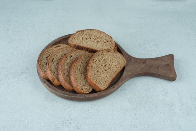 小麦木板上的黑麦面包片有机面包新鲜