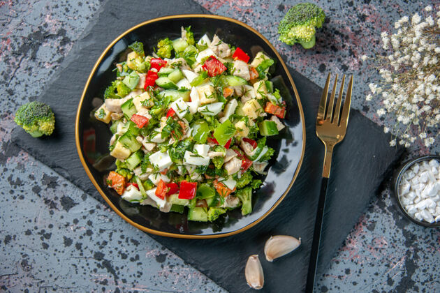 午餐俯视图美味蔬菜沙拉由黄瓜奶酪和西红柿组成 内盘为深色背景 健康饮食 彩色午餐 美食番茄蔬菜正餐