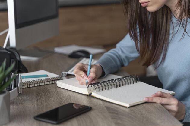 工人在媒体领域工作的女人在笔记本上写东西女性计算机员工
