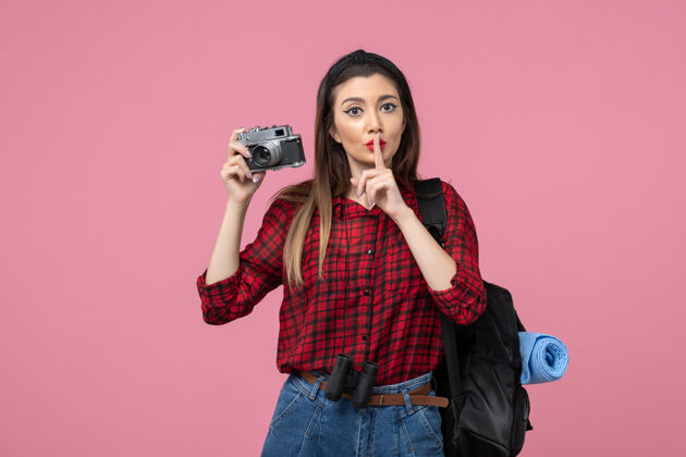 年轻女性前视图年轻女性用相机在粉色背景上拍照女性照片颜色拍摄照片美女