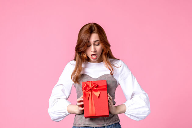 礼品正面图：年轻女性 红色包装 粉色背景 三月横向性感礼品 照片平等 女性香水礼品香水年轻女性