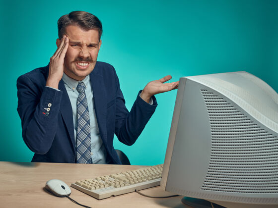 担心头痛的商人坐在电脑前的桌子旁悲伤随意压力