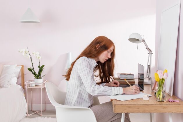 模特在家里用笔记本电脑工作的女人年轻人室内科技