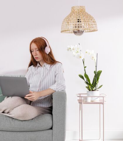 房子在家里用笔记本电脑工作的女人耳机年轻人模型