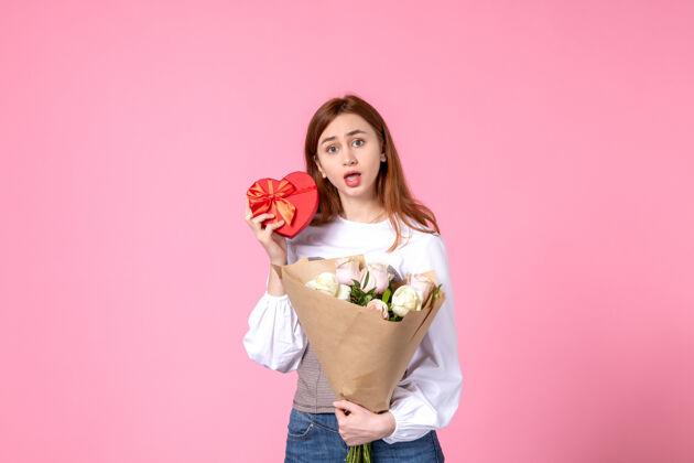 花束正面图：年轻女性 带鲜花 在粉色背景上作为妇女节礼物 水平三月平等 女性约会 玫瑰女人爱礼物花礼物