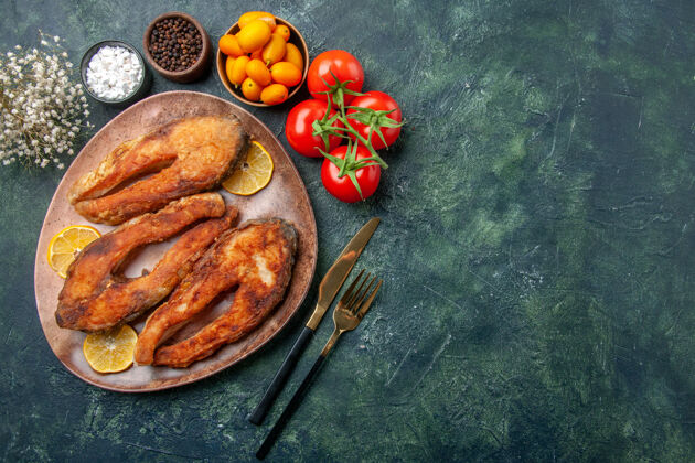 蔬菜上图：棕色盘子上的炸鱼和柠檬片 混合颜色的桌子上的西红柿金橘 有自由空间食物南瓜盘子