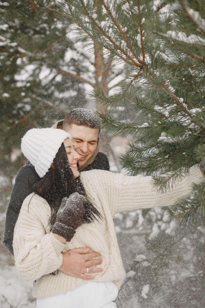 人一对情侣在雪林中散步的生活方式照片浪漫冬天家庭