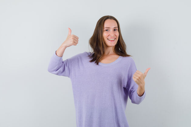 女性穿着淡紫色上衣的年轻女子竖起大拇指 看上去很乐观女士衬衫姿势
