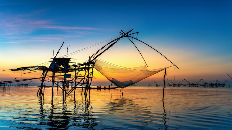 湖美丽的日出和渔网浸在pakpra在phatthalung 泰国河流网海洋