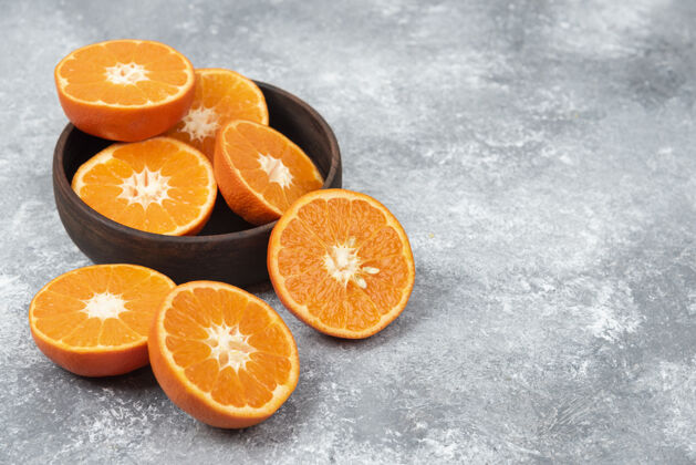成熟把新鲜多汁的橙子切片放在木碗里切整个柑橘